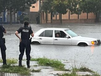 Un auto se encuentra detenido en medio de una calle inundada de Montevideo.